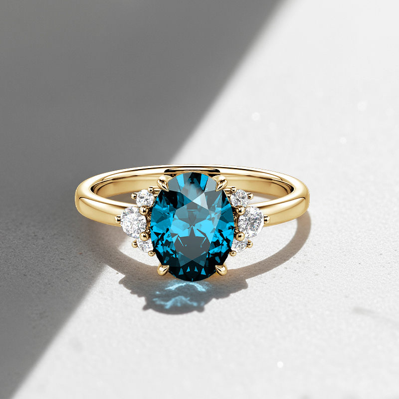 side-stone engagement ring with Swiss blue center stone