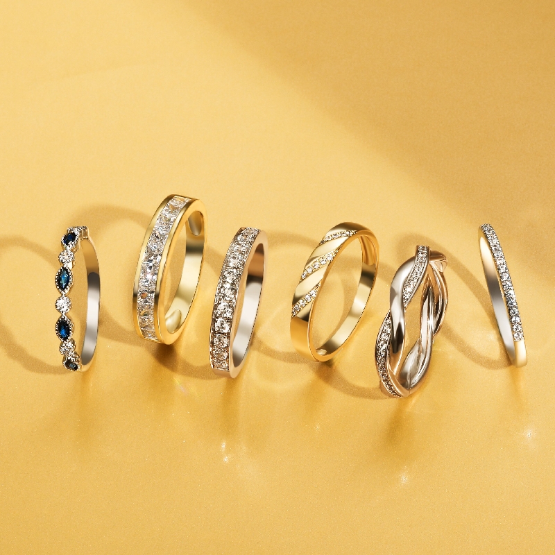 different diamond and gold wedding bands on a gold background