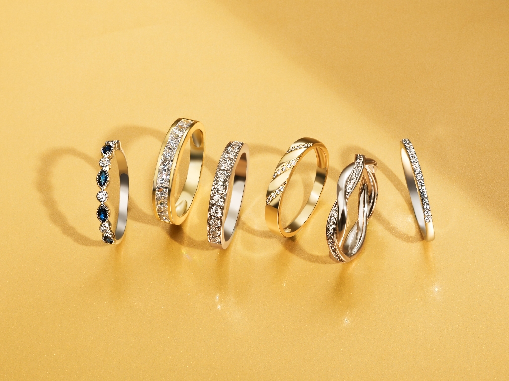 different diamond and gold wedding bands on a gold background