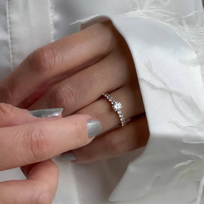 Hand wearing a white gold promise ring